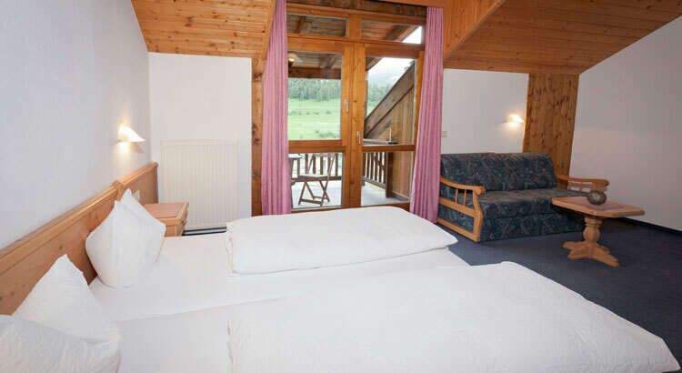Zimmer mit Doppelbett und Balkon im Ferienhaus Auer